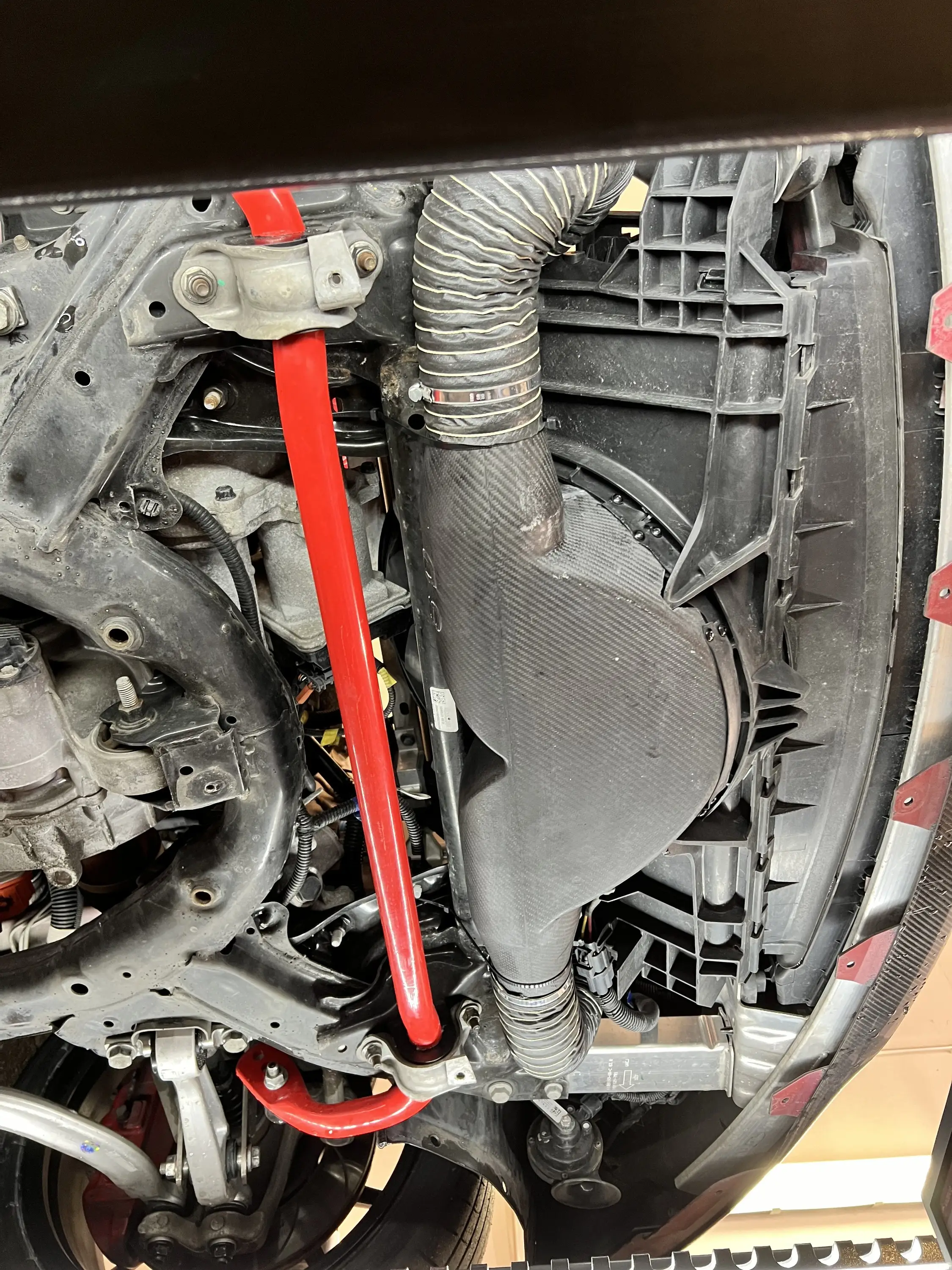 Blick unter den Vorderwagen: roter Stabilisator und Luftführung.
