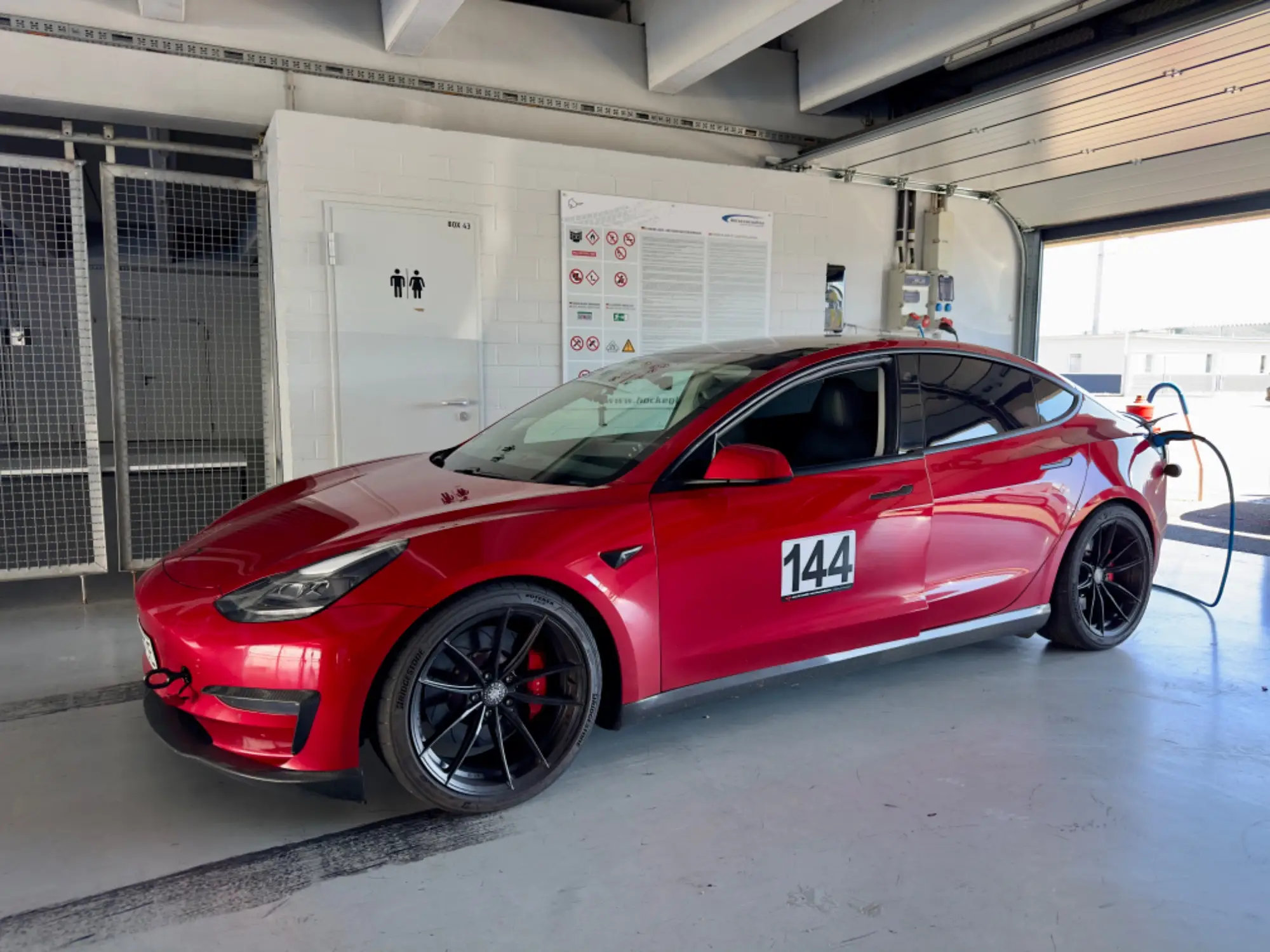 Rotes Tesla Model 3 Performance „Red Devil“ in der Box, Hockenheimring, 10. Juni 2024.