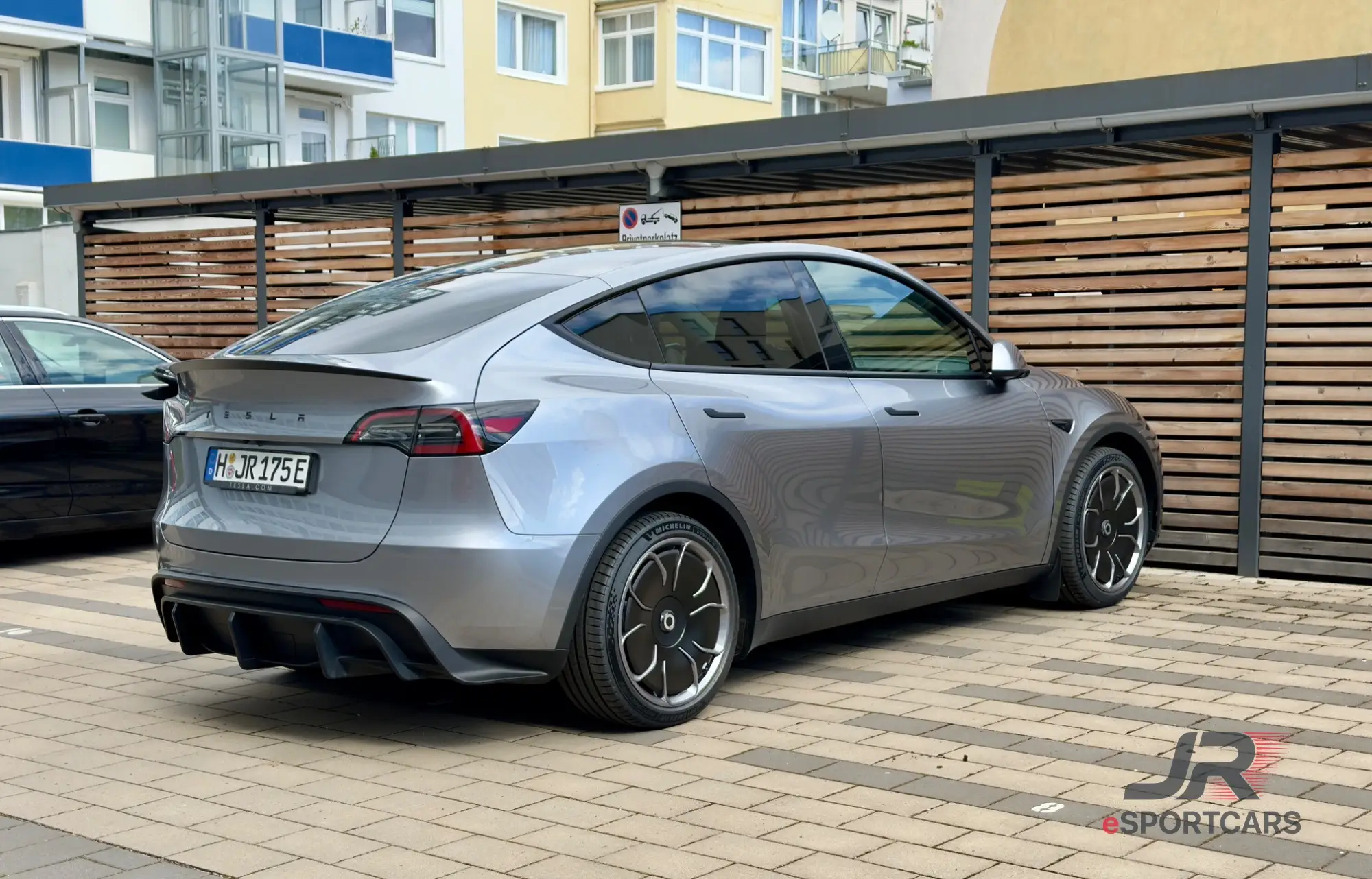 Silbergrauer Tesla Model Y Long Range „Silver Star“, Schrägansicht von hinten.