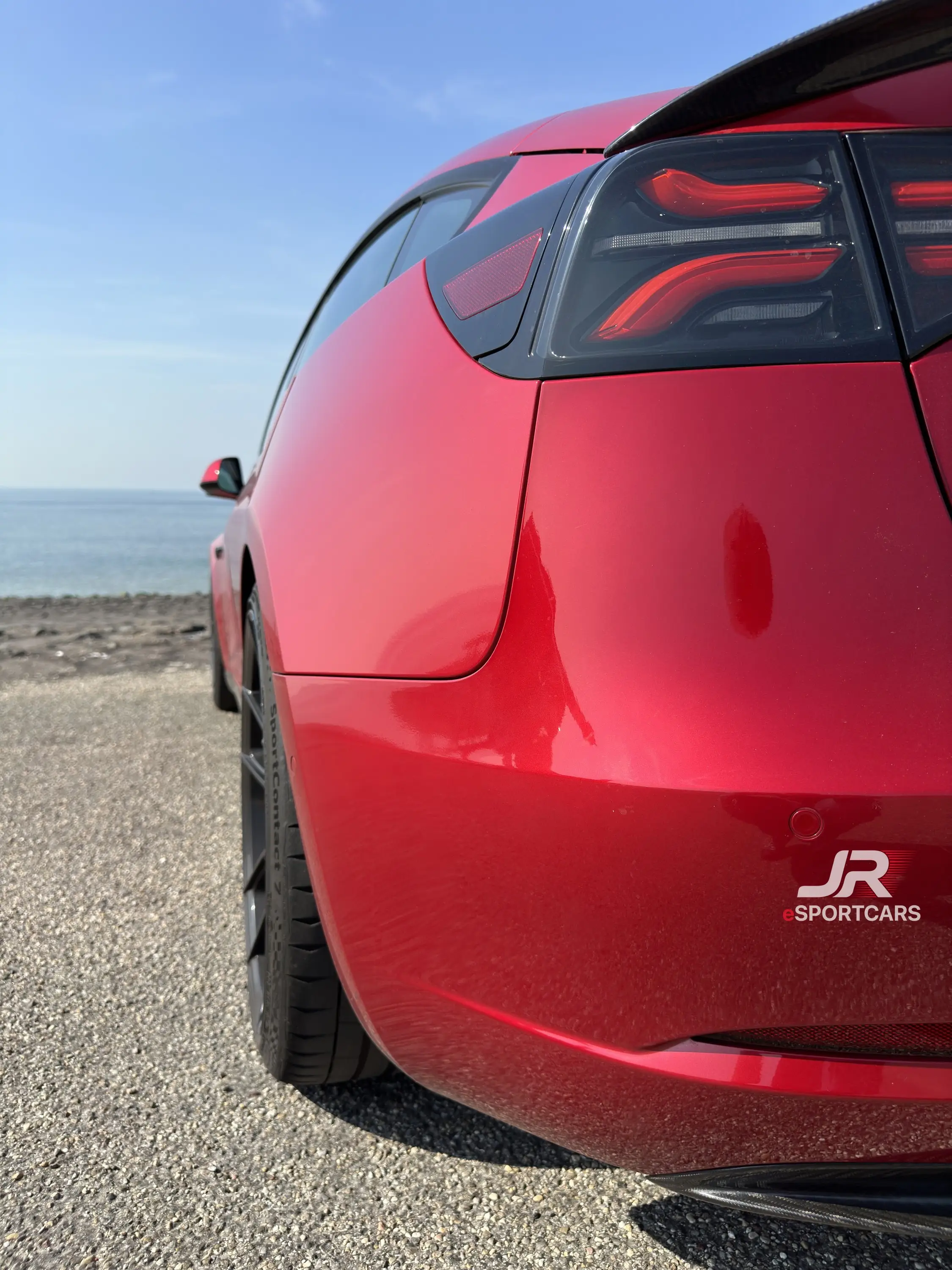 Heck von schräg hinten mit dunklen Rückleuchten, am Meer.