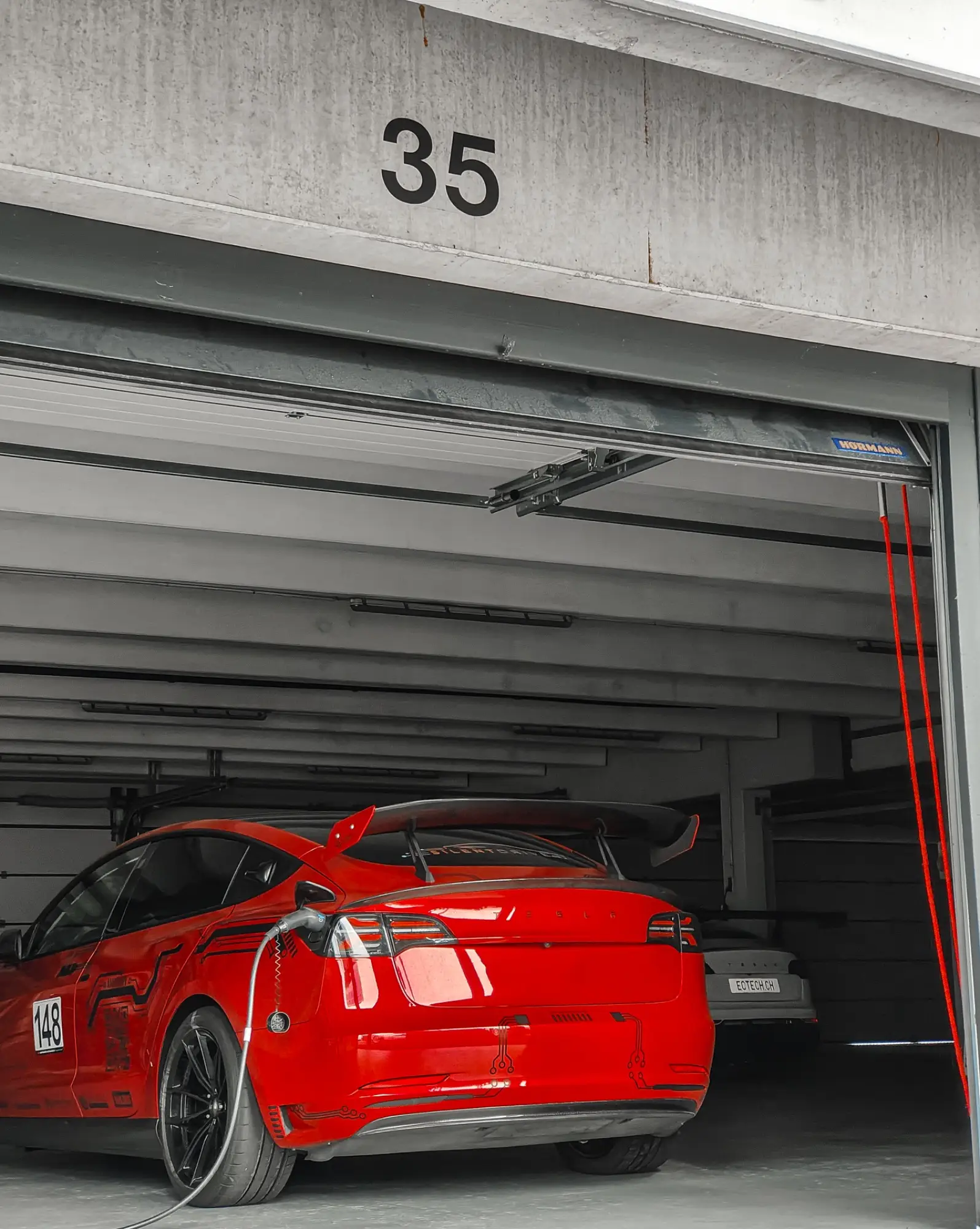 Rotes Tesla Model 3 Performance „Red Devil“ in der Box, Heckansicht, Hockenheimring, 2. Juni 2025.