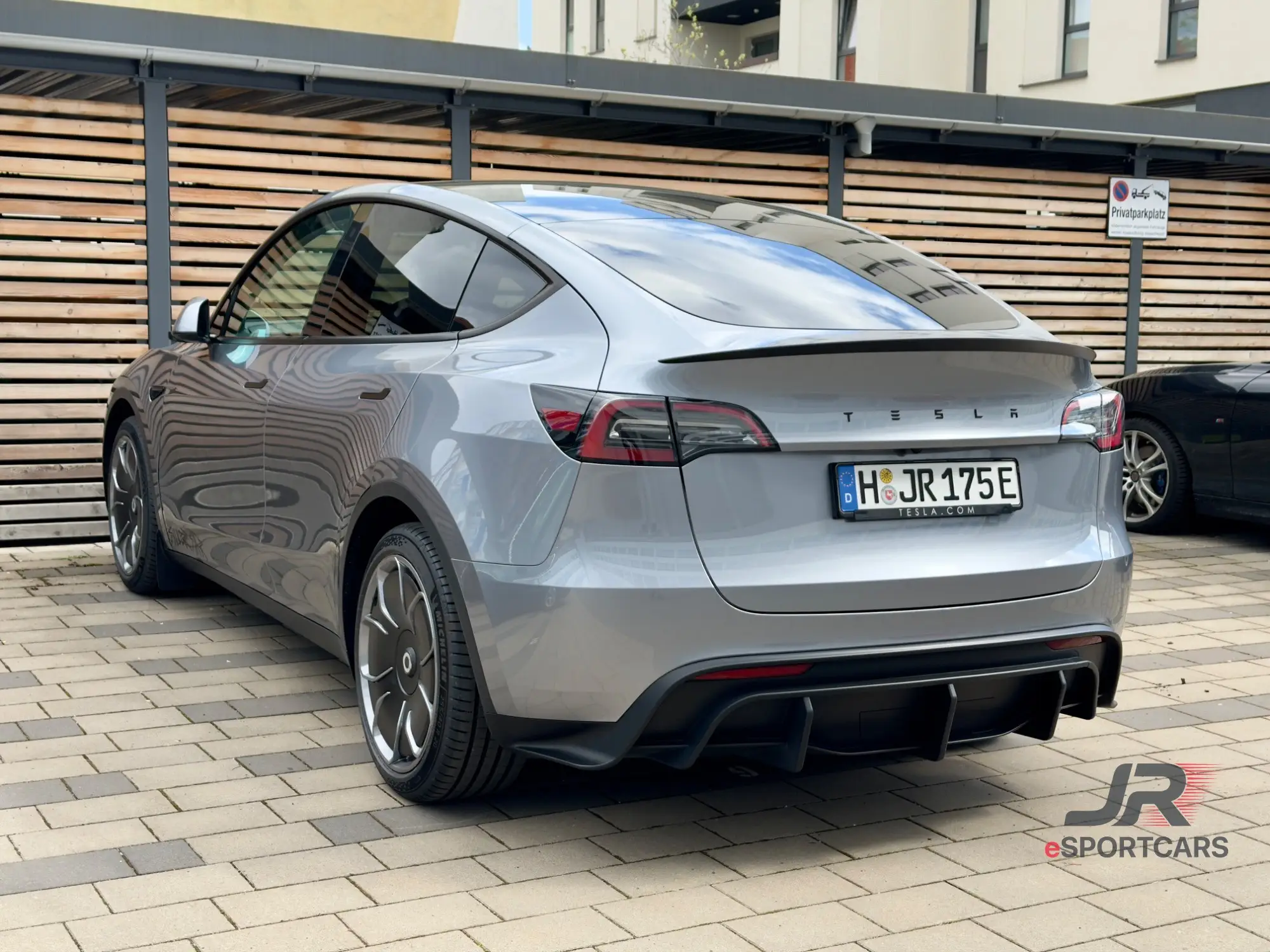 Silbergrauer Tesla Model Y Long Range „Silver Star“, Schrägansicht von hinten.