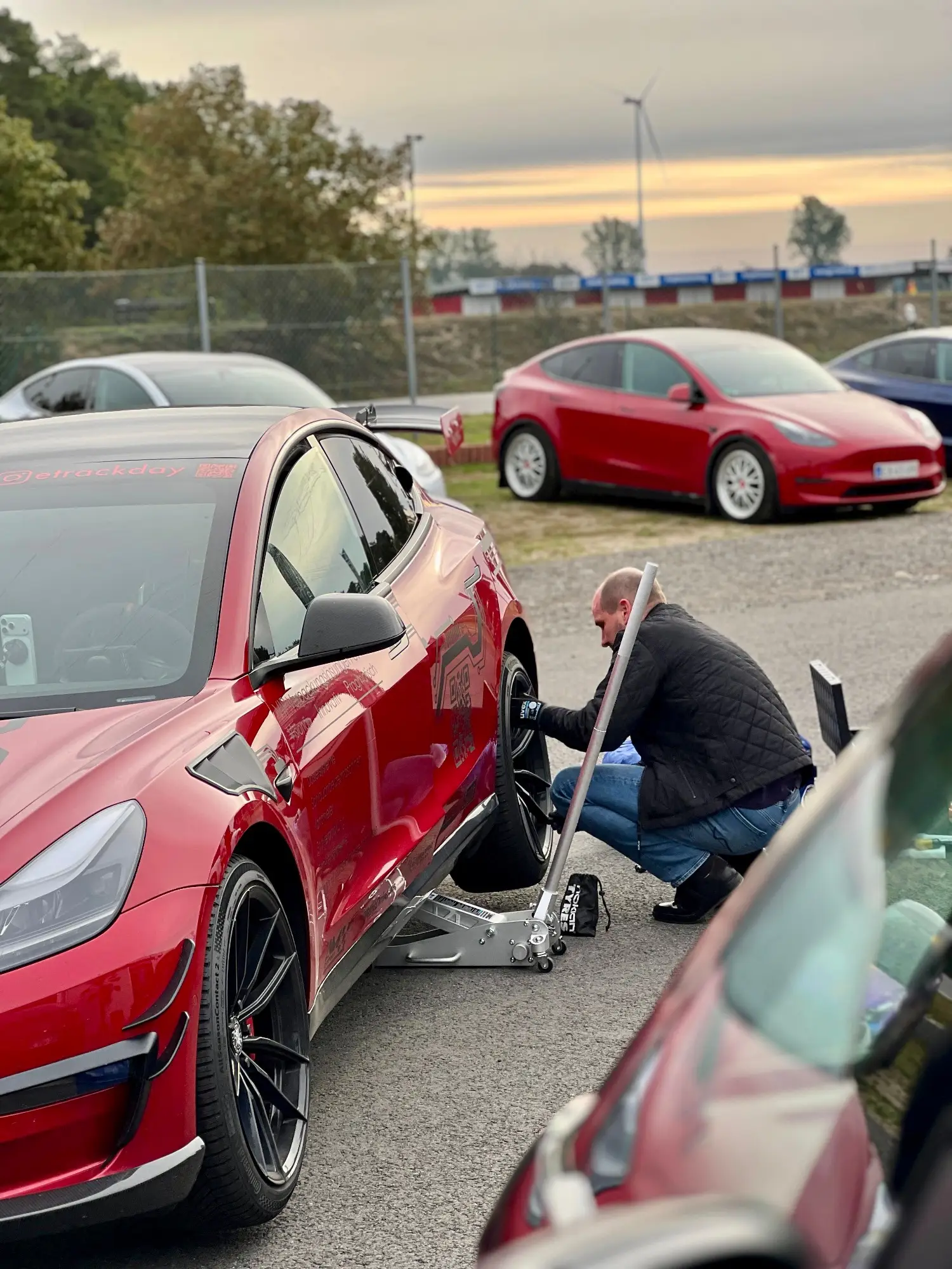 Rotes Tesla Model 3 Performance „Red Devil“ im Fahrerlager, aufgebockt mit Wagenheber, Spreewaldring, 4. Oktober 2025.