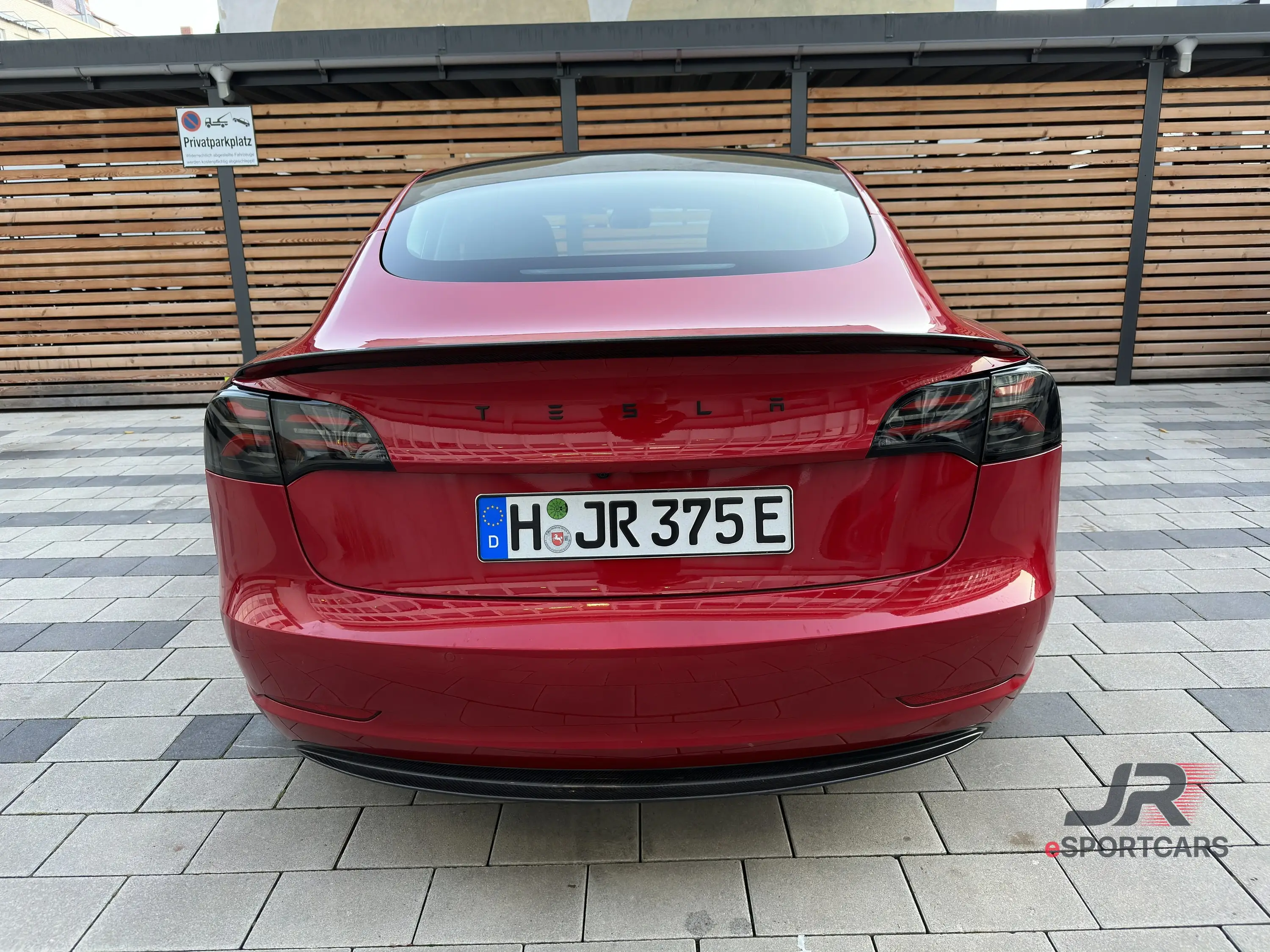 Heckansicht mit schwarzem Tesla-Schriftzug und dunklen Rückleuchten.